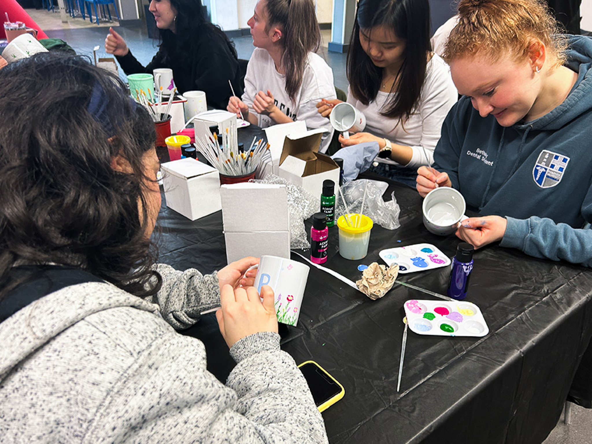 Students painting mugs at a Crafternoon