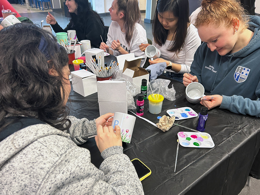 Women painting mugs at a table
