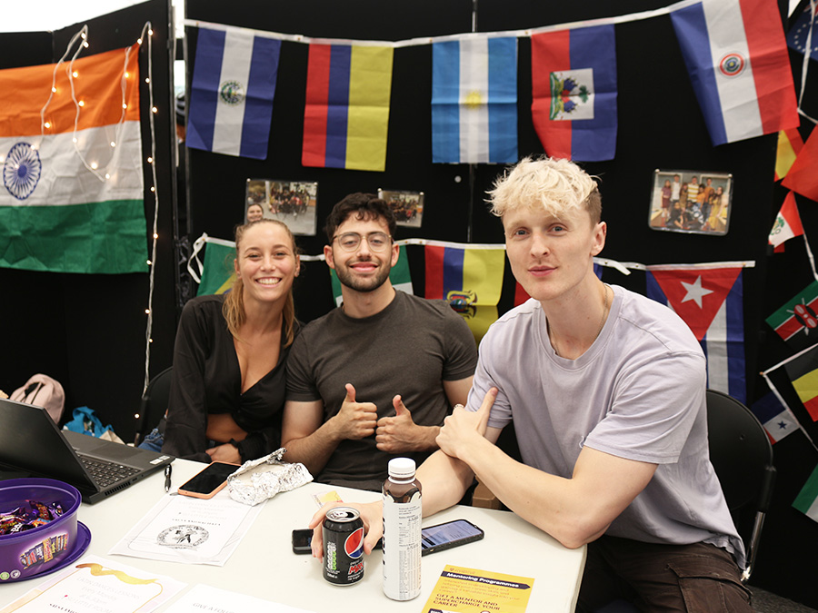 Three students on a stall at the Societies Fair